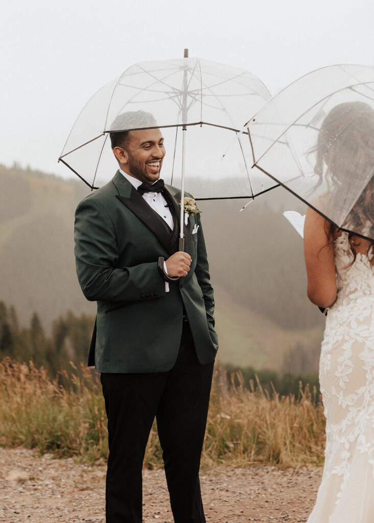 Groom laughing during Bride's personal vows atop Vail Mountain in CO.