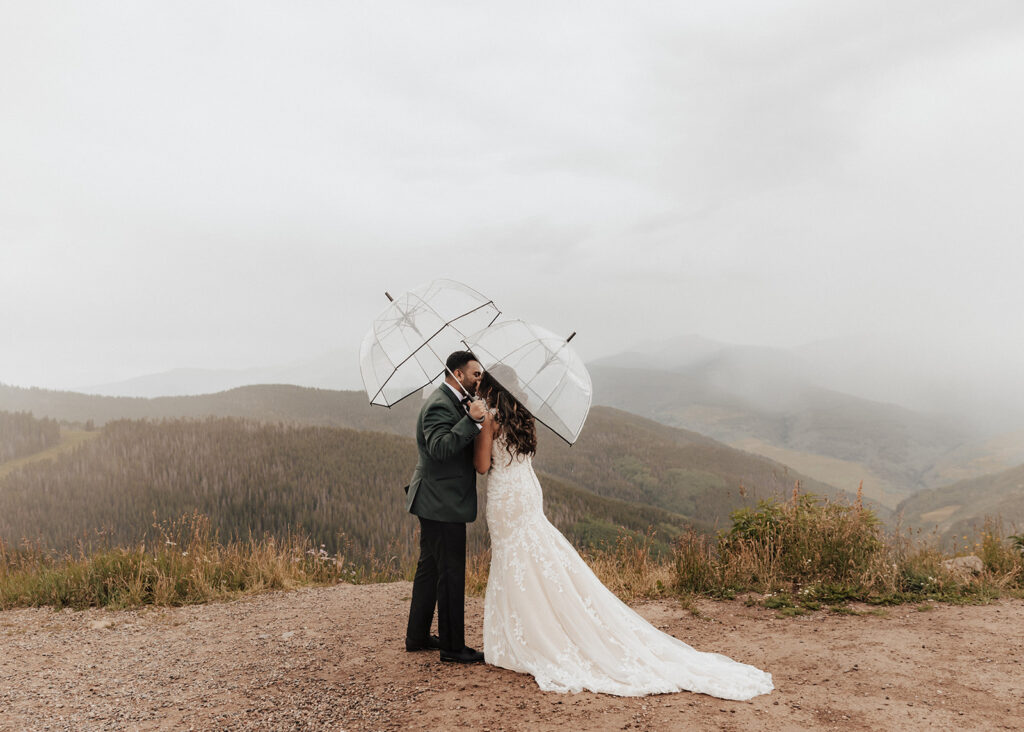 Bride and groom kiss atop Vail Mountain in Colorado.