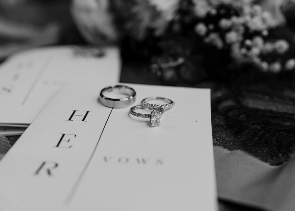 Wedding rings with bridal bouquet and vow books