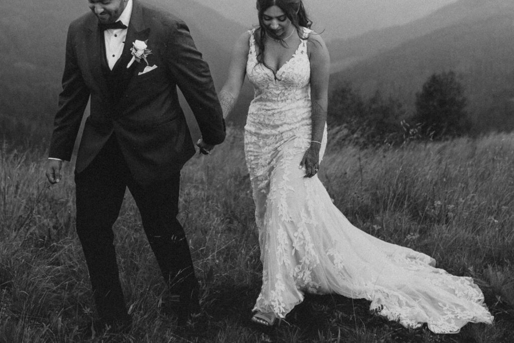 Bride and groom holding hands, walking atop Vail Mountain in CO.