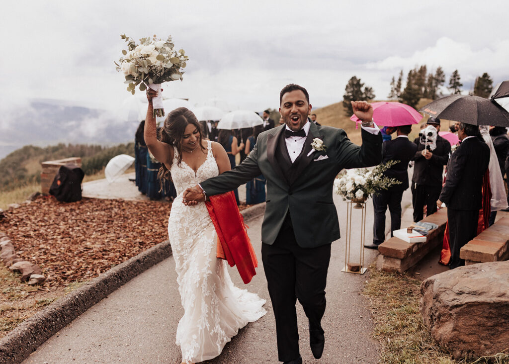 Bride and groom leaving wedding ceremony atop Vail Mountain in CO.