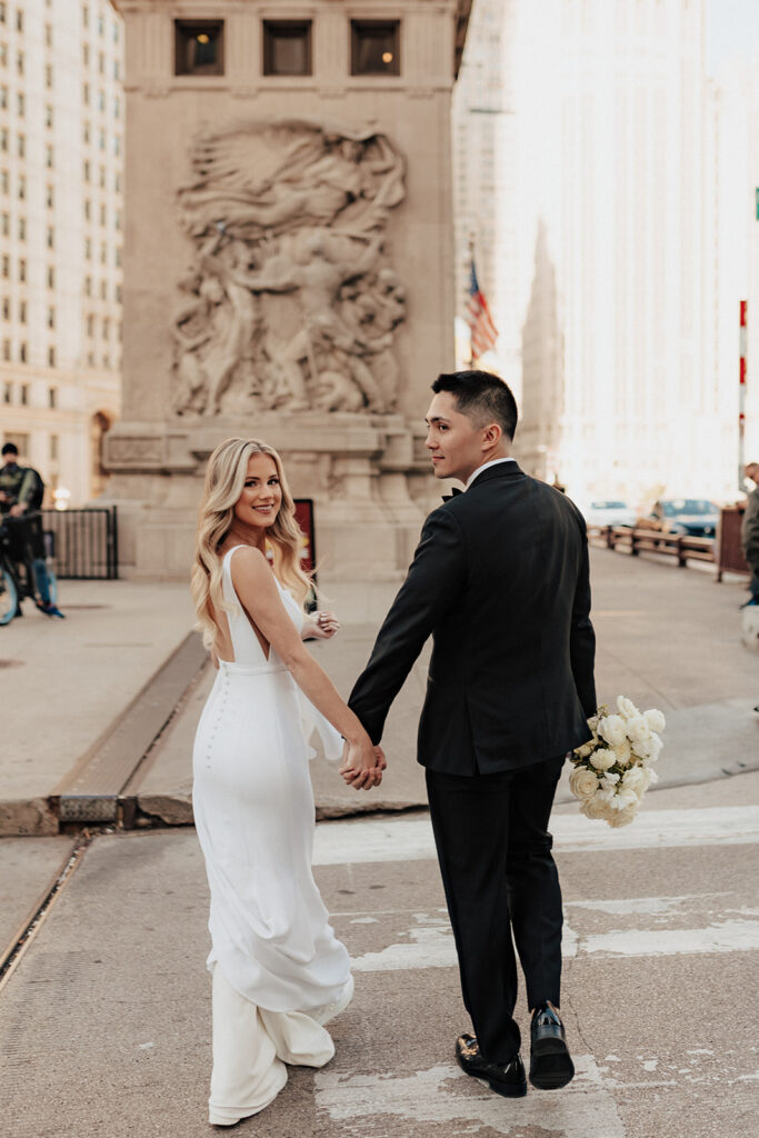 Bride and groom crossing Michigan Avenue in Chicago, IL