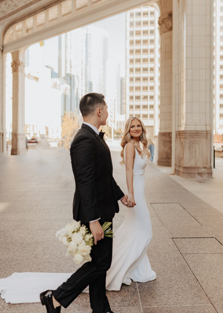 Bride and groom walking The Wrigley Building in Chicago, IL