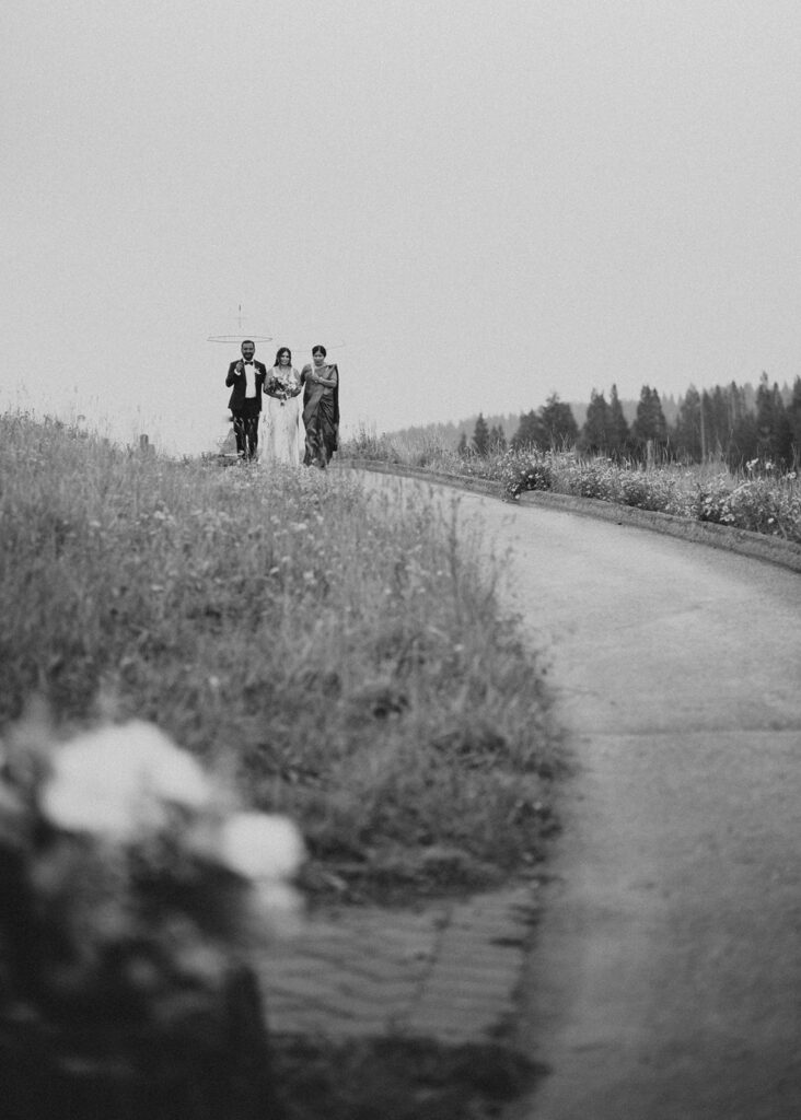 Bride walking down the aisle with parents atop Vail Mountain in CO.