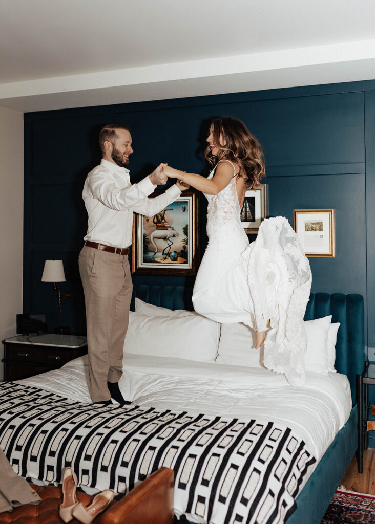 Bride and Groom jumping on bed at The Ramble Hotel in Denver, CO