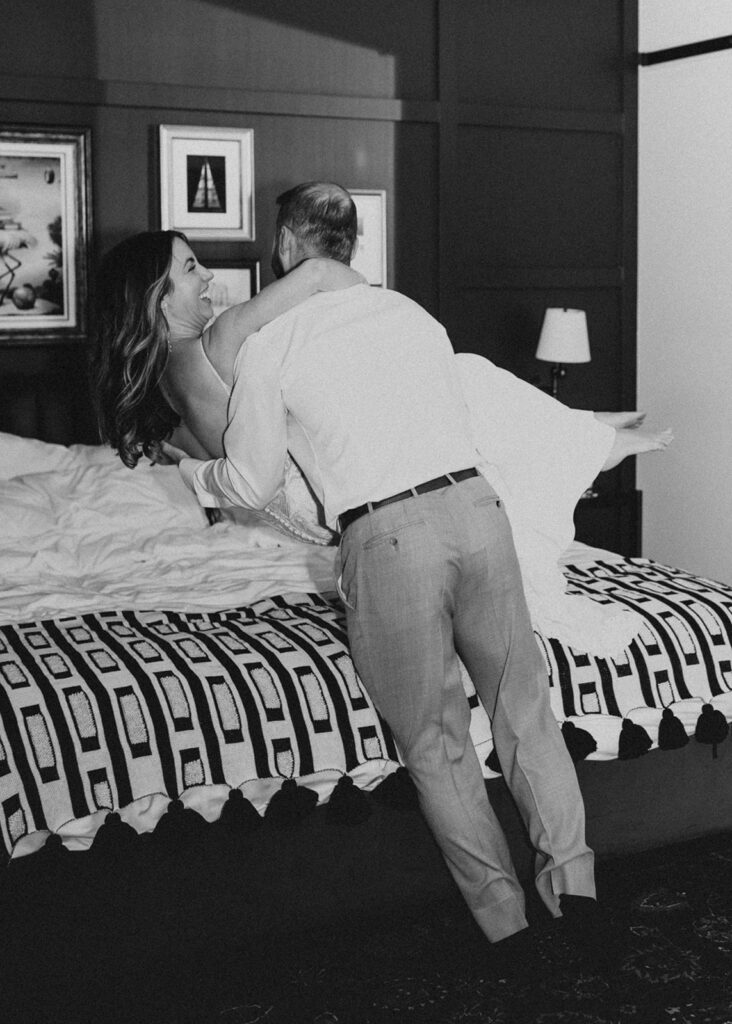 Bride and Groom jumping on bed at The Ramble Hotel in Denver, CO