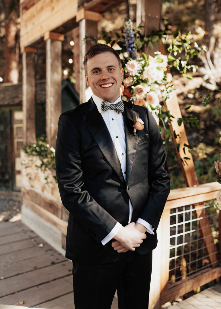 Groom smiling under the covered bridge at Blackstone Rivers Ranch.