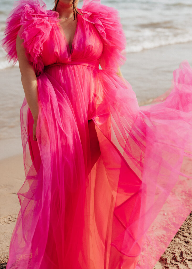 Hot pink maternity dress blowing in the wind.