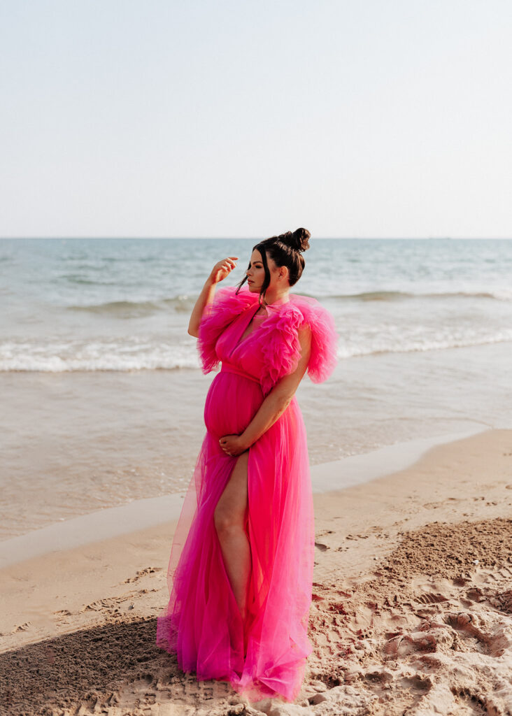 Pregnant woman posing on the beach for maternity photos in Chicago.