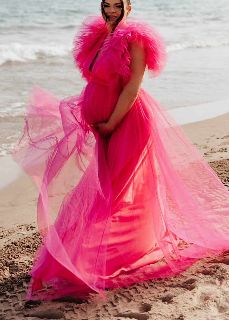 Hot pink maternity dress blowing in the wind.