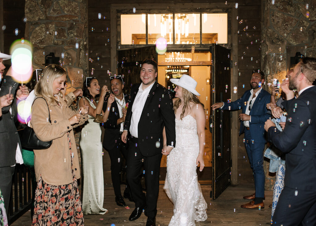 Bride and groom exit their wedding reception at Black Canyon Inn in Estes Park, CO