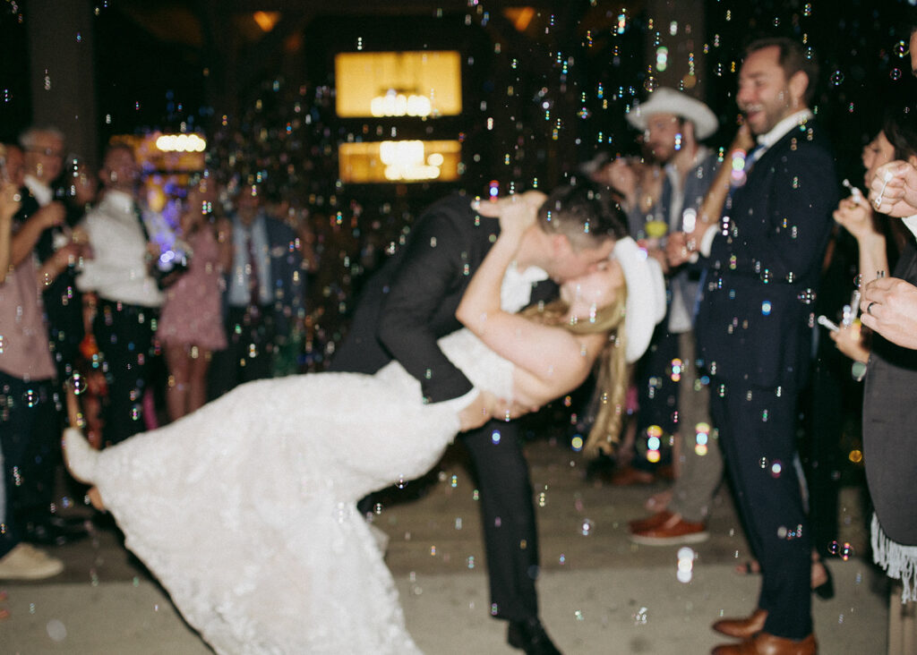 Bride and groom exit their wedding reception at Black Canyon Inn in Estes Park, CO