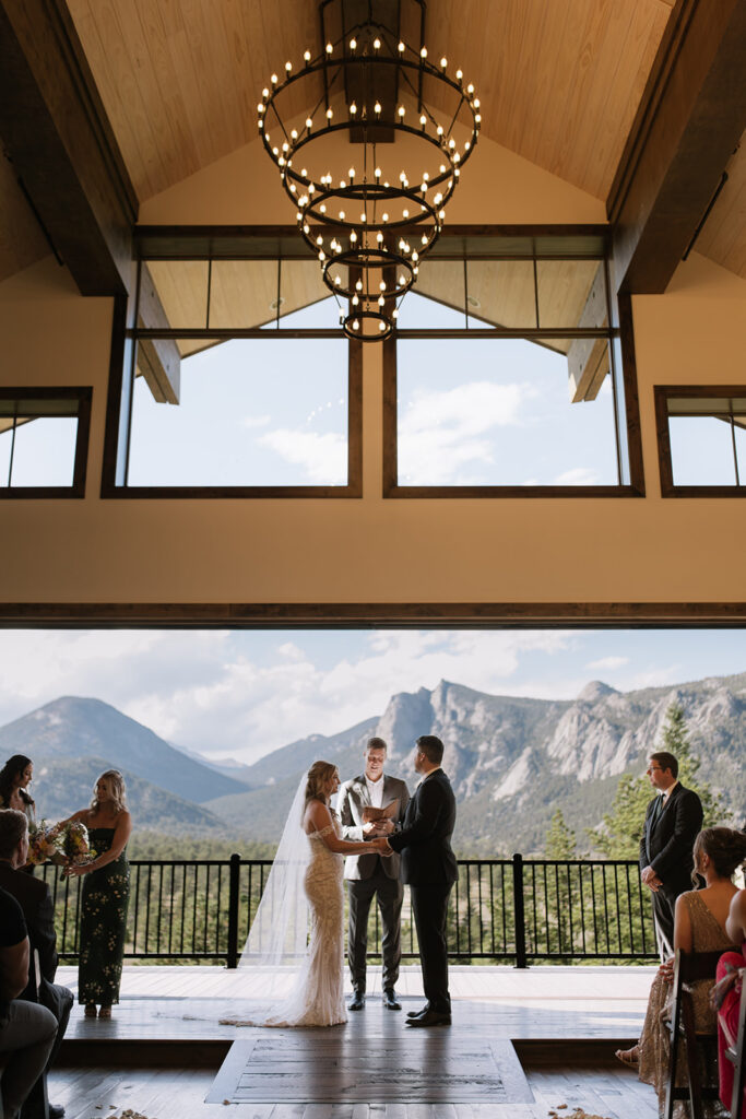 Bride and groom holding hands during ceremony at Black Canyon Inn in Estes Park, CO