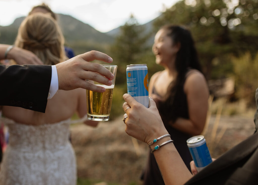 Groom cheersing with guest during cocktail hour