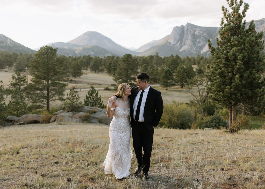Bride and groom walking with Rocky Mountains behind them